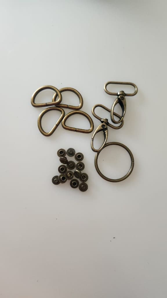 Brass bag hardware packet with D-rings, hooks, and rivets by Plaasjaap